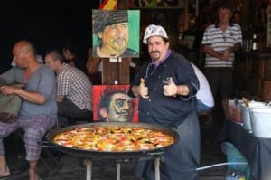 A chef at a food shop in Chatuchak market poses with a pan of paella.
