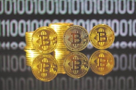 A collection of bitcoin tokens stand in front of an illustration of binary code in this arranged photograph in London last month. In Indonesia, fintech startup Blossom Finance uses Bitcoin to help Muslim entrepreneurs and small businesses by offering microfinance services.