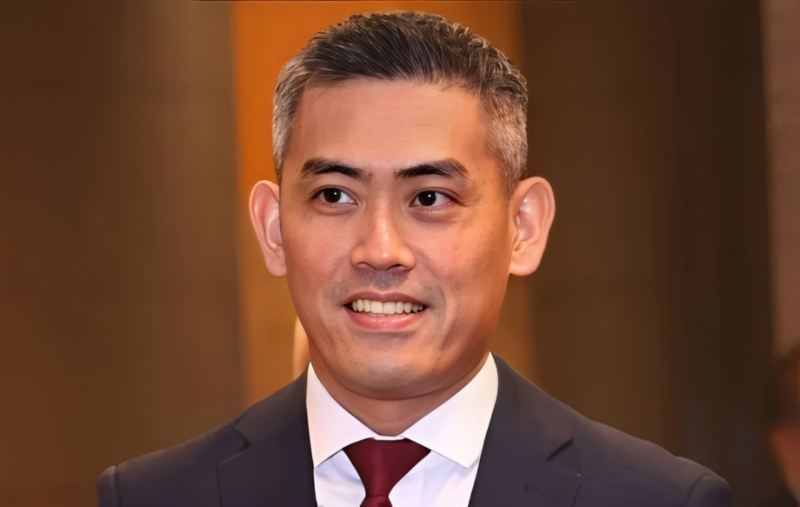 Headshot of man in a suit and tie looking to the side of the camera