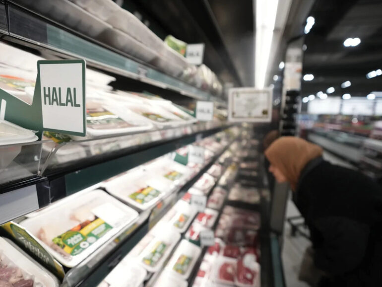 Woman looking at Halal section of meat in a groccery store